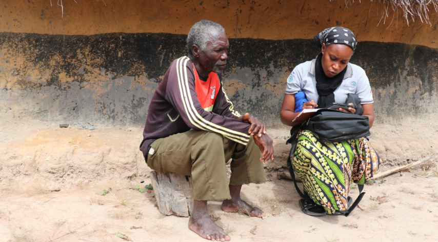 A WorldFish survey enumerator, right, interviews a man in Zambia